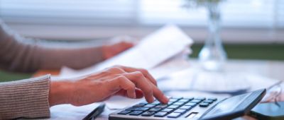 Hands managing finances and preparing tax calculations